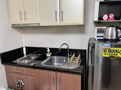 a kitchen with a sink and a refrigerator at ZG-150Newport in Manila