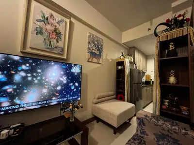 a living room with a large flat screen tv on the wall at Beautiful 1bed condo Nr Airport, MOA, Makati, Bay in Manila