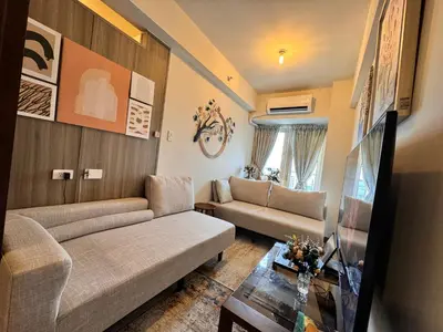 a living room with a couch and a table at Beautiful 1bed condo Nr Airport, MOA, Makati, Bay in Manila