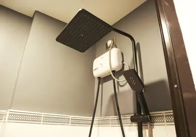 a speaker and a hair dryer on the wall of a bathroom at mySTAY Hotel BGC East in Manila
