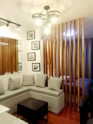 a living room with a couch and a bed at The Linear Makati Condo Stunning Hotel Type Interior in Manila