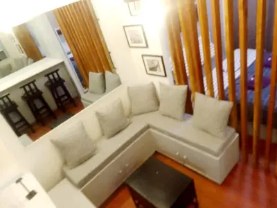 a living room with a white couch and a bed at The Linear Makati Condo Stunning Hotel Type Interior in Manila