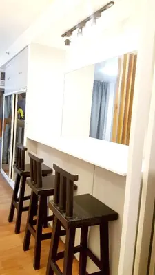 a kitchen with a counter with chairs and a mirror at The Linear Makati Condo Stunning Hotel Type Interior in Manila
