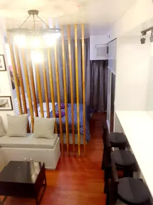 a living room with a couch and a bed at The Linear Makati Condo Stunning Hotel Type Interior in Manila