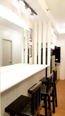 a bar in a room with two chairs and a counter at The Linear Makati Condo Stunning Hotel Type Interior in Manila