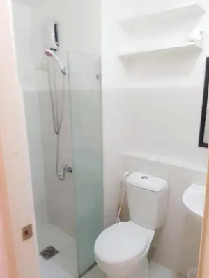 a bathroom with a shower with a toilet and a sink at The Linear Makati Condo Stunning Hotel Type Interior in Manila