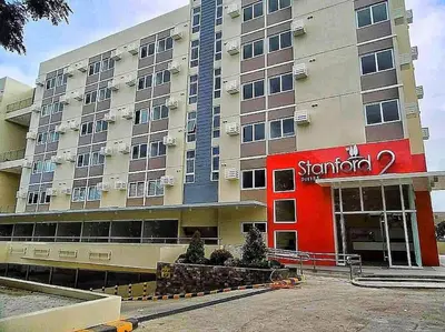 a hotel with a red sign on the front of it at Lilian Stanford Suites 2 South Forbes Inchican Silang Cavite in Silang