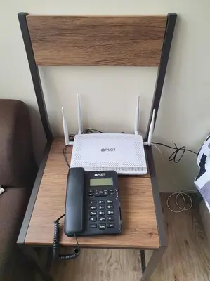 a desk with a phone and a laptop on it at Lilian Stanford Suites 2 South Forbes Inchican Silang Cavite in Silang