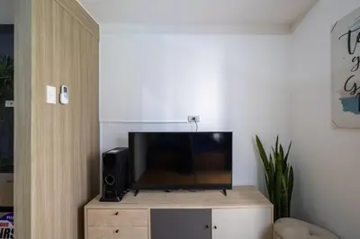 a flat screen tv sitting on top of a wooden entertainment center at Bella Vita at Grace Residences in Manila