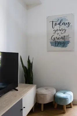a living room with a tv and a desk and stool at Bella Vita at Grace Residences in Manila