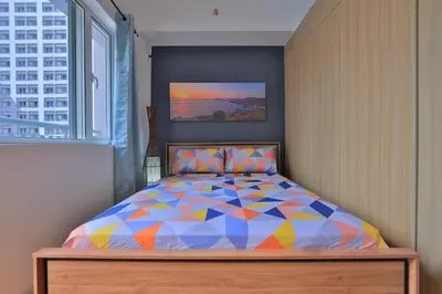 a bedroom with a colorful bed with a window at Bella Vita at Grace Residences in Manila