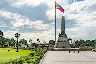 a flag on top of a monument in a park at USA embassy front suite Pearl of the Orient in Manila