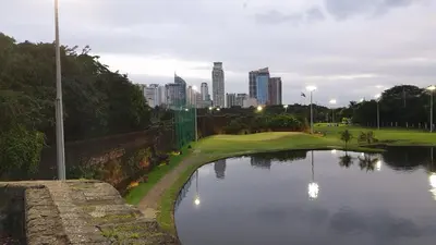 a golf course with a pond in the middle of a city at MANILA BAY FRONT DELUX Pearl of the orient in Manila
