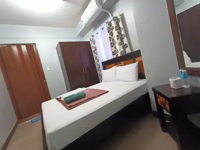 a bedroom with a bed with a towel on it at Taj's Condotel in Manila