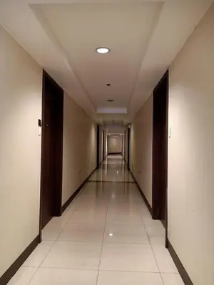 an empty hallway in a building with a long corridor at Taj's Condotel in Manila