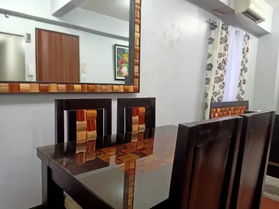 a dining room with a table and chairs at Taj's Condotel in Manila