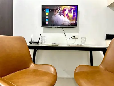 two chairs in a room with a television on a table at Sea Residences Tower F Angel 0975 - 811 - 9490 in Manila