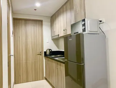 a small kitchen with a refrigerator and a microwave at Sea Residences Tower F Angel 0975 - 811 - 9490 in Manila