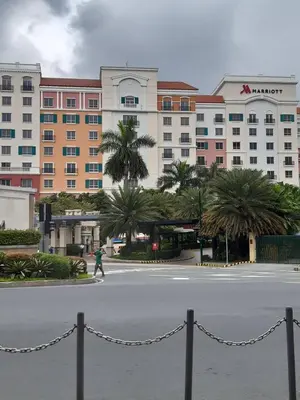 a person crossing a street in front of a hotel at Sarasota Residential Resort cluster 4 Unit 6B and 6C by Manny Newport Blvd, across NAIA T3 & near Resorts World Manila, Pasay City in Manila