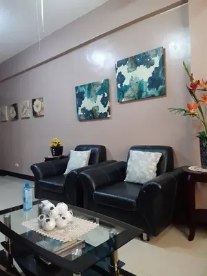 a living room with two black leather couches and a table at Sarasota Residential Resort cluster 4 Unit 6B and 6C by Manny Newport Blvd, across NAIA T3 & near Resorts World Manila, Pasay City in Manila