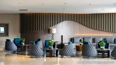 a lobby with chairs and tables and a staircase at Sabina's one bedroom condo at Shore tower C in Manila