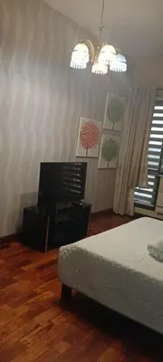 a bedroom with a bed and a desk and a television at 18F staycation in Manila