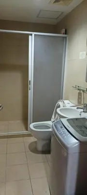 a bathroom with a shower and a toilet and a sink at 18F staycation in Manila