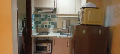 a small kitchen with a refrigerator and a sink at 18F staycation in Manila