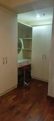 a room with a desk and some white cabinets at 18F staycation in Manila
