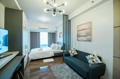 a living room with a couch and a bed at Serene Escape at Air Residences 2160 Makati in Manila