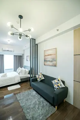 a living room with a bed and a couch at Serene Escape at Air Residences 2160 Makati in Manila
