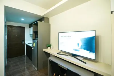 a flat screen tv on a desk in a bathroom at Serene Escape at Air Residences 2160 Makati in Manila
