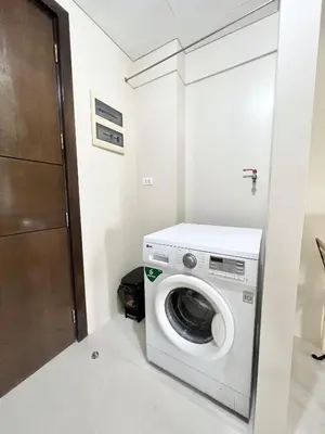 a washing machine in a small room with a door at Luxury Hotel Type Condo Near NAIA Manila Airport in Manila