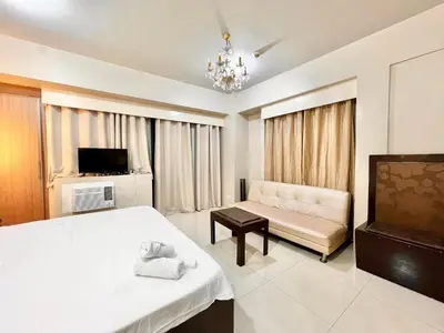 a bedroom with a bed and a couch and a television at Luxury Hotel Type Condo Near NAIA Manila Airport in Manila