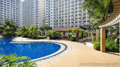 a swimming pool in front of a large building at Shore Residences Mall of Asia Pool View 200mbps Free Wi-Fi in Manila