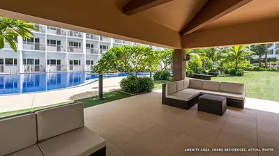 a patio with a couch and a building at Shore Residences Mall of Asia Pool View 200mbps Free Wi-Fi in Manila