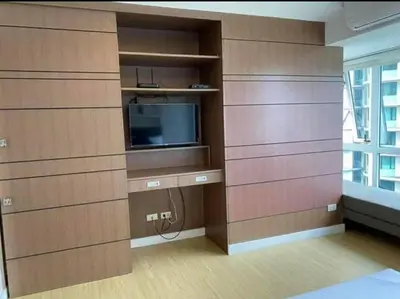 a room with wooden walls and a tv in a room at A2J Luxury 1BR BGC Balcony Suite Near BurgosCircle in Manila