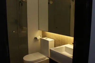 a bathroom with a toilet and a sink and a mirror at A2J Luxury 1BR BGC Balcony Suite Near BurgosCircle in Manila
