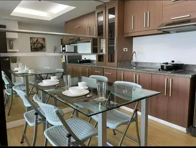 a kitchen with a glass table and chairs in it at A2J Luxury 1BR BGC Balcony Suite Near BurgosCircle in Manila