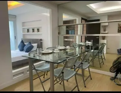 a dining room with a table and chairs and a bed at A2J Luxury 1BR BGC Balcony Suite Near BurgosCircle in Manila