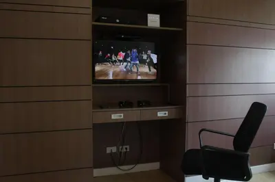 a room with a tv in a wall with a chair at A2J Luxury 1BR BGC Balcony Suite Near BurgosCircle in Manila
