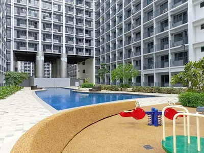 a large apartment building with a pool and a playground at Home away from Home in Manila