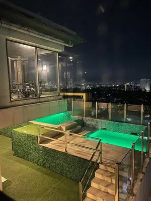a swimming pool on the roof of a building at night at Spacious One Bedroom 20888 in Manila