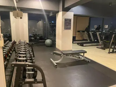 a gym with several rows of treadms and machines at Spacious One Bedroom 20888 in Manila
