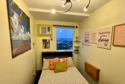a small bedroom with a bed and a window at Pandora’s Nest in Manila