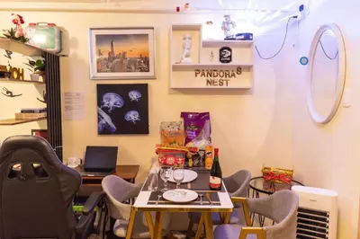 a dining room with a table and chairs and a laptop at Pandora’s Nest in Manila