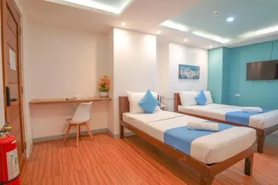 a hotel room with two beds and a desk at Arzo Hotel Premier in Manila