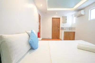 a bedroom with a white bed with a blue pillow at Arzo Hotel Premier in Manila