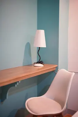 a desk with a white chair and a lamp at Arzo Hotel Premier in Manila