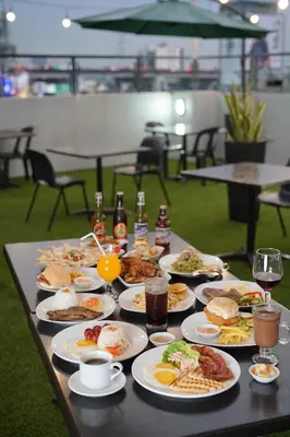 a table topped with plates of food and drinks at Arzo Hotel Premier in Manila